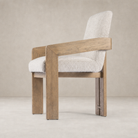 Ash dining armchair with a textured cream upholstery and sturdy wooden frame.