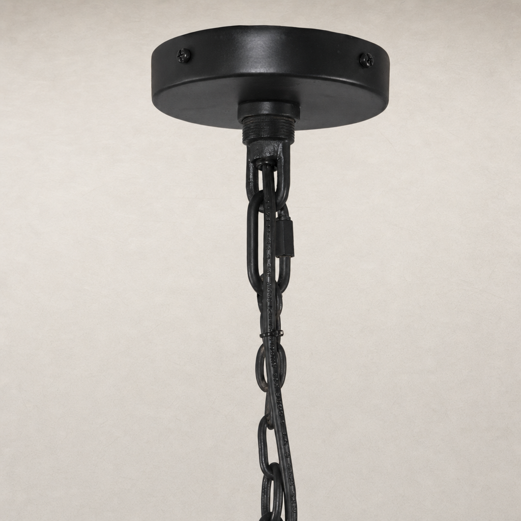 Antiqued iron chandelier with decorative chain and circular ceiling plate.