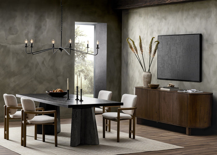 Antiqued iron chandelier with six arms, elegantly illuminating a modern dining area.