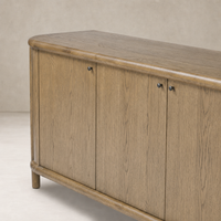 Laurent Sideboard in amber oak showcasing rounded edges and sleek black knobs.