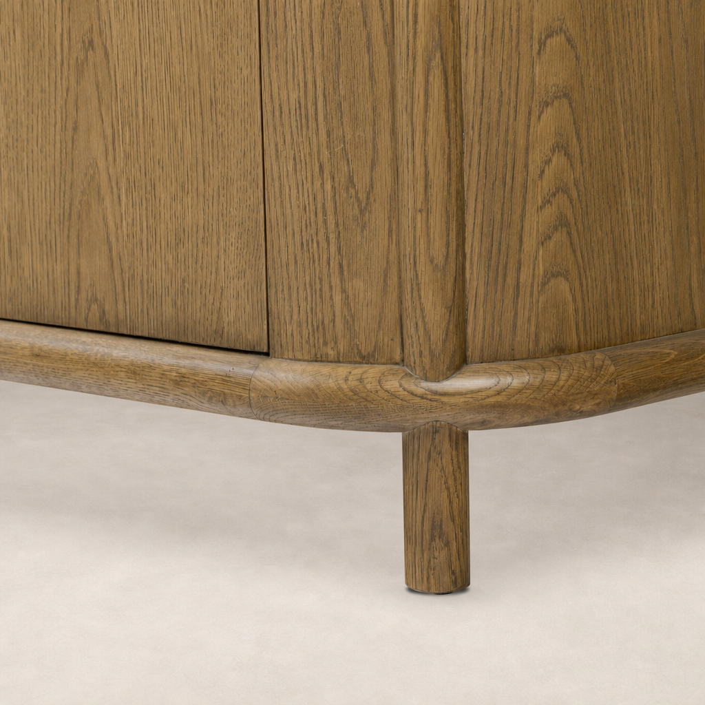 Close-up of the Laurent Sideboard in Amber Oak, showcasing its smooth rounded base and natural wood grain.