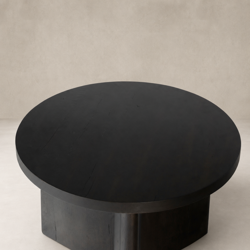 Rumi End Table with a sleek, round black top and sturdy base.