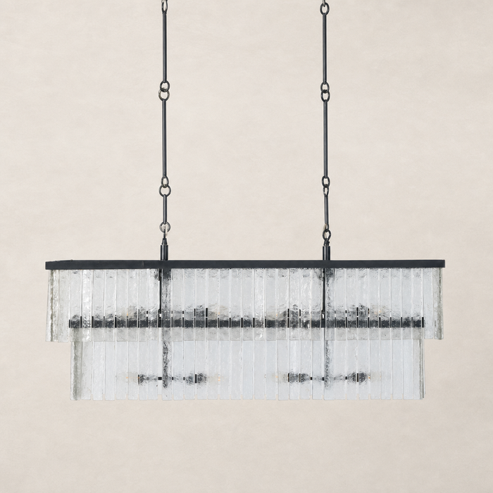 Antiqued iron linear chandelier with glass ribbed shades and adjustable chain.