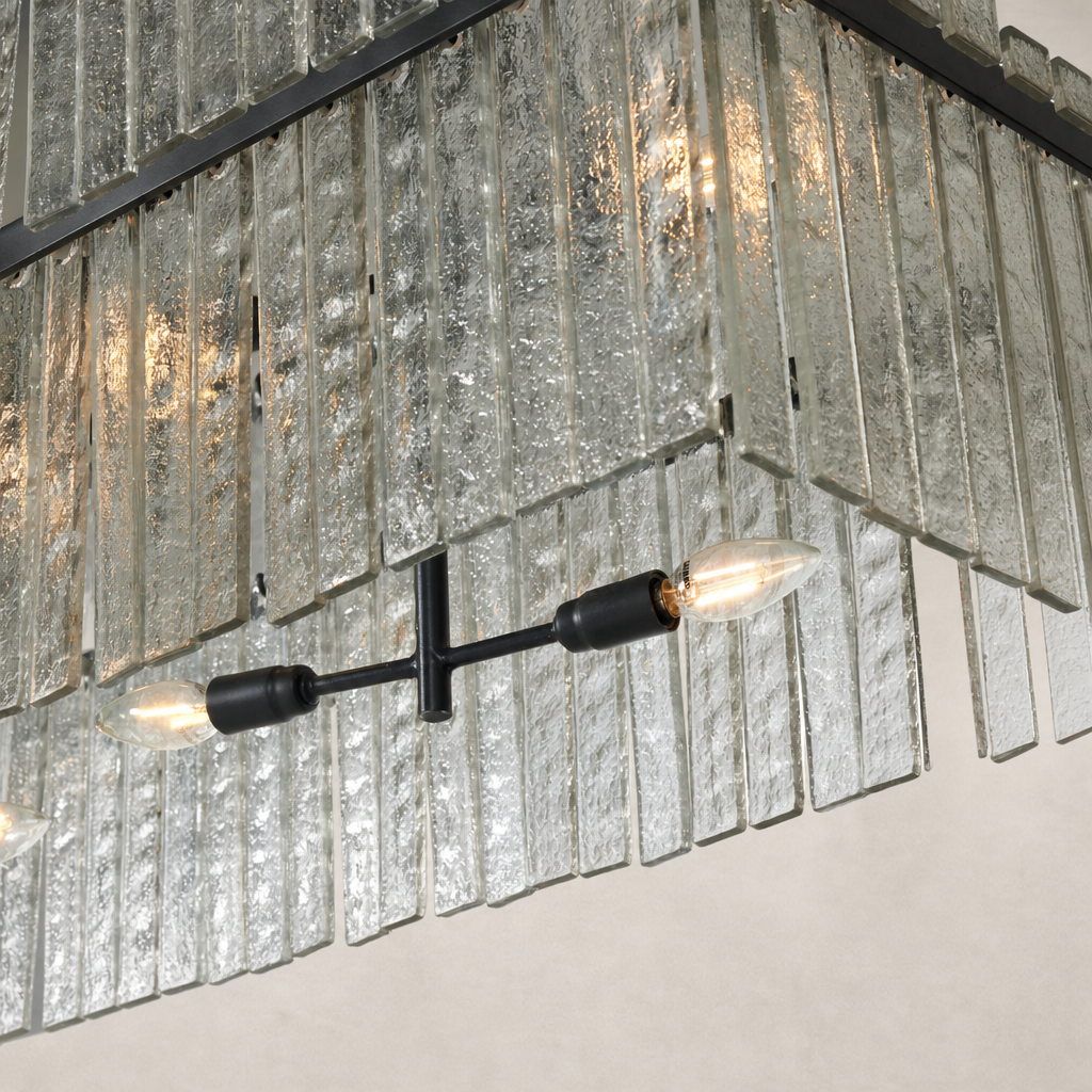 Antiqued iron linear chandelier with textured glass panels and exposed bulbs.