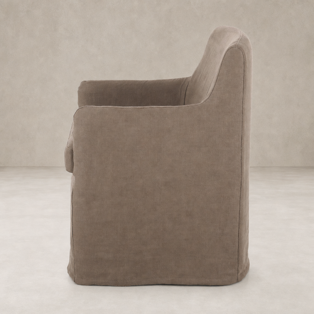 Side view of a Brussels Mushroom slipcover dining chair with curved arms.