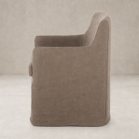 Side view of a Brussels Mushroom slipcover dining chair with curved arms.