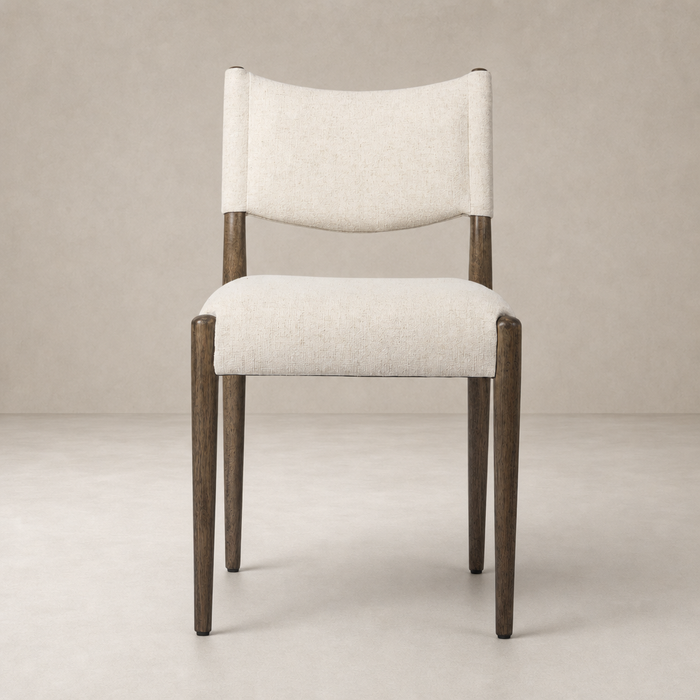 Mira Armless Dining Chair in Antwerp Natural with soft fabric and sleek wooden legs.