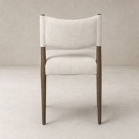 Mira Armless Dining Chair in Antwerp Natural with rounded back and wooden legs.