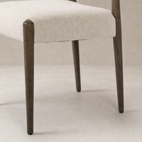 Mira Armless Dining Chair in Antwerp Natural with textured fabric seat and wooden legs.