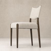 Mira Armless Dining Chair in Antwerp Natural features a textured upholstery and sleek wooden legs.