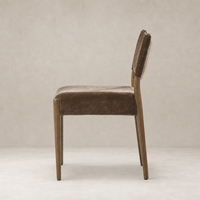 Side view of the Mira Armless Dining Chair in Altair Mushroom fabric with sleek wooden legs.