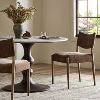 Mira Armless Dining Chair in Altair Mushroom featuring soft, textured upholstery and a minimalist design.