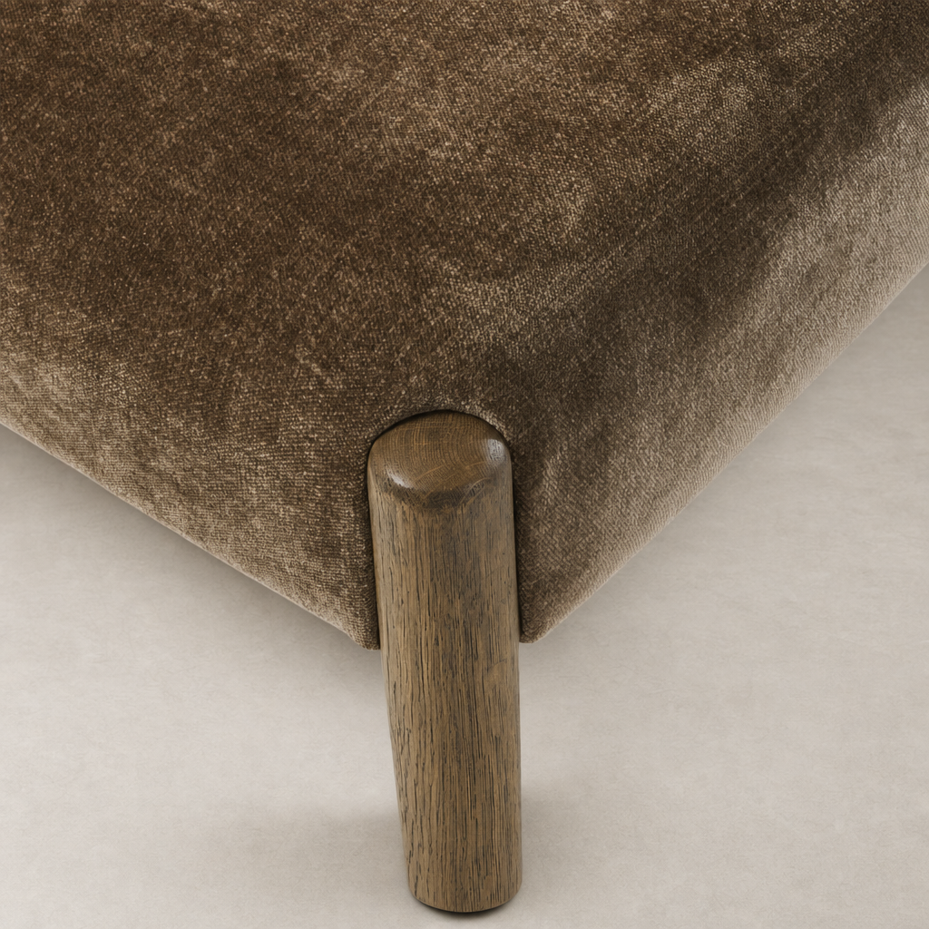 Close-up of Mira Armless Dining Chair in Altair Mushroom, showcasing soft fabric and wooden leg.