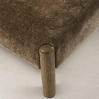 Close-up of Mira Armless Dining Chair in Altair Mushroom, showcasing soft fabric and wooden leg.