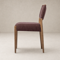Mira Armless Dining Chair in Laughlin Plum with wooden legs and textured upholstery.