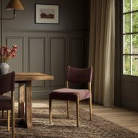Mira Armless Dining Chair in Laughlin Plum, featuring wooden legs and a modern design.