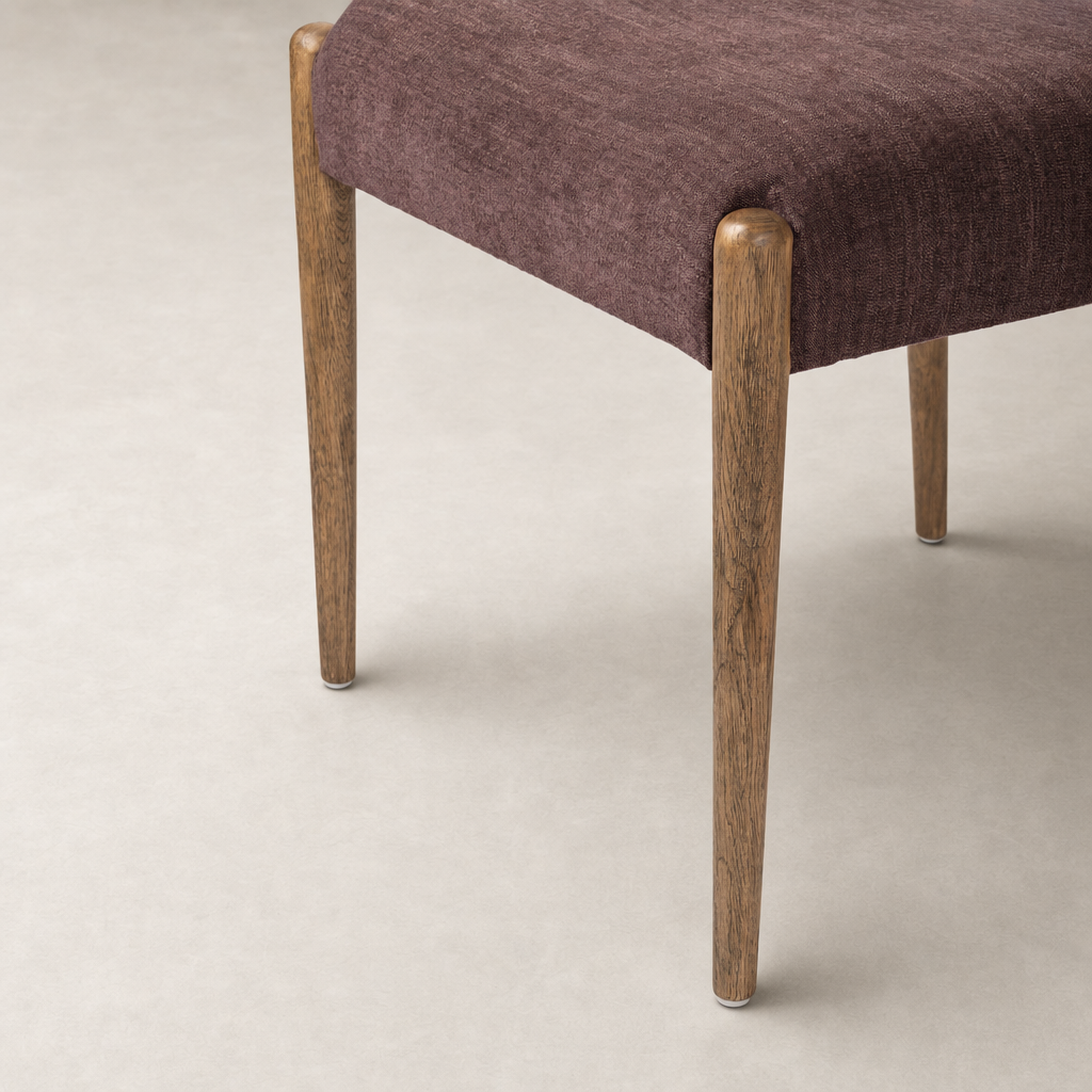 Mira Armless Dining Chair in Laughlin Plum with wooden legs and textured upholstery.