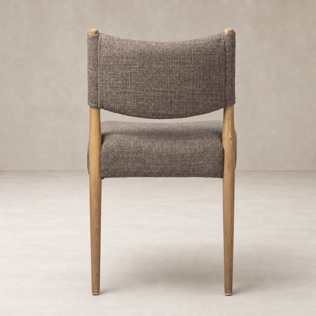 Mira Armless Dining Chair in Saxon Mink with curved backrest and wooden legs.