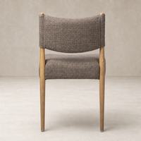 Mira Armless Dining Chair in Saxon Mink with curved backrest and wooden legs.