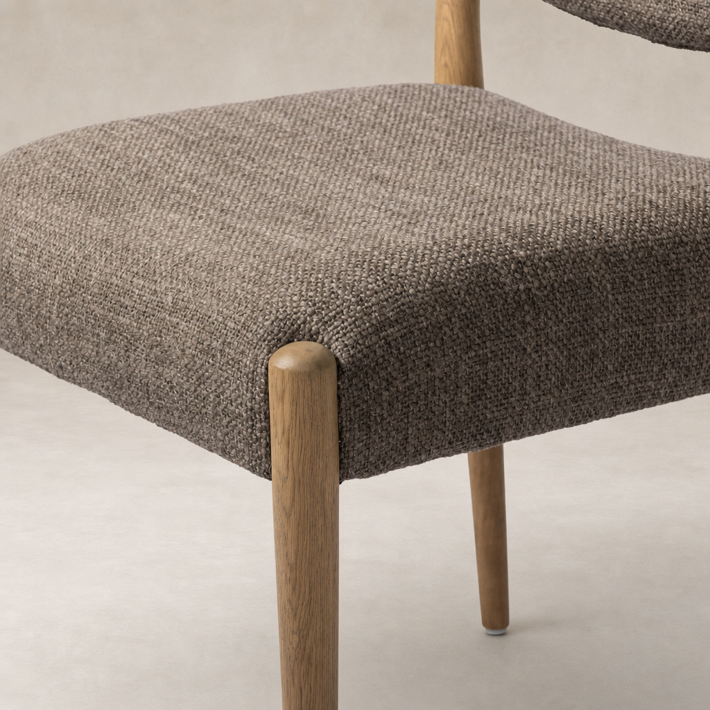 Mira Armless Dining Chair in Saxon Mink featuring a soft textured seat and wooden legs.