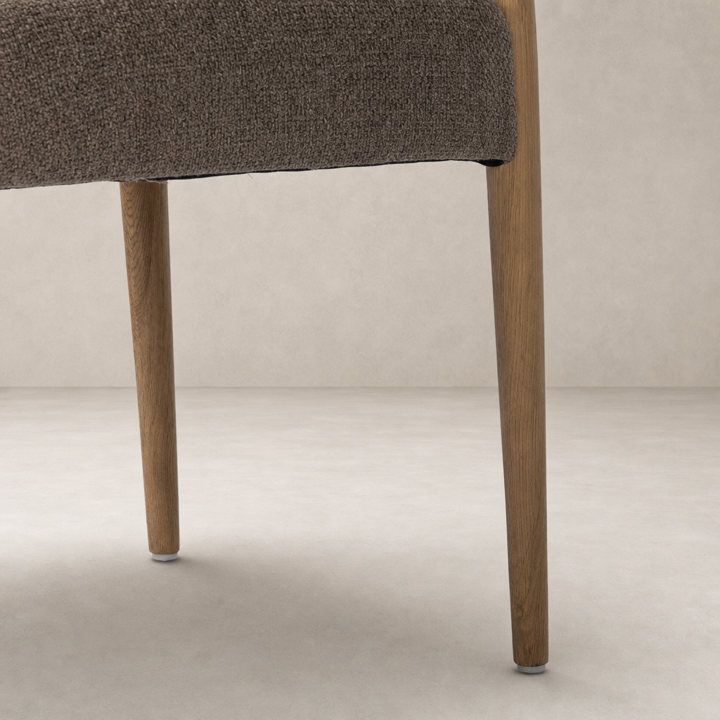 Mira Armless Dining Chair in Saxon Mink with textured fabric and sturdy wooden legs.