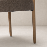Mira Armless Dining Chair in Saxon Mink with textured fabric and sturdy wooden legs.
