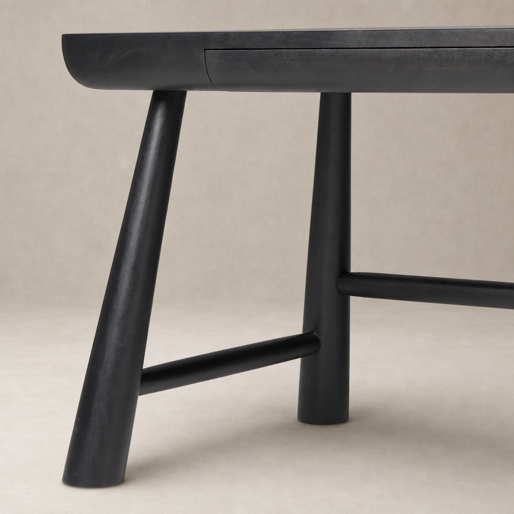 Koa Desk featuring worn black acacia with sleek angled legs and subtle drawer.