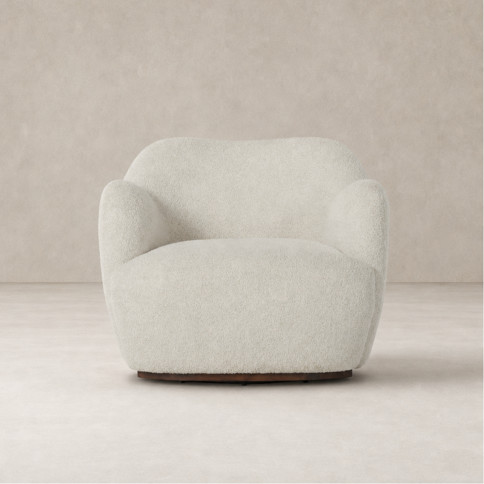 Poppy Swivel Chair in Sheldon Ivory featuring a rounded, plush design and soft texture.