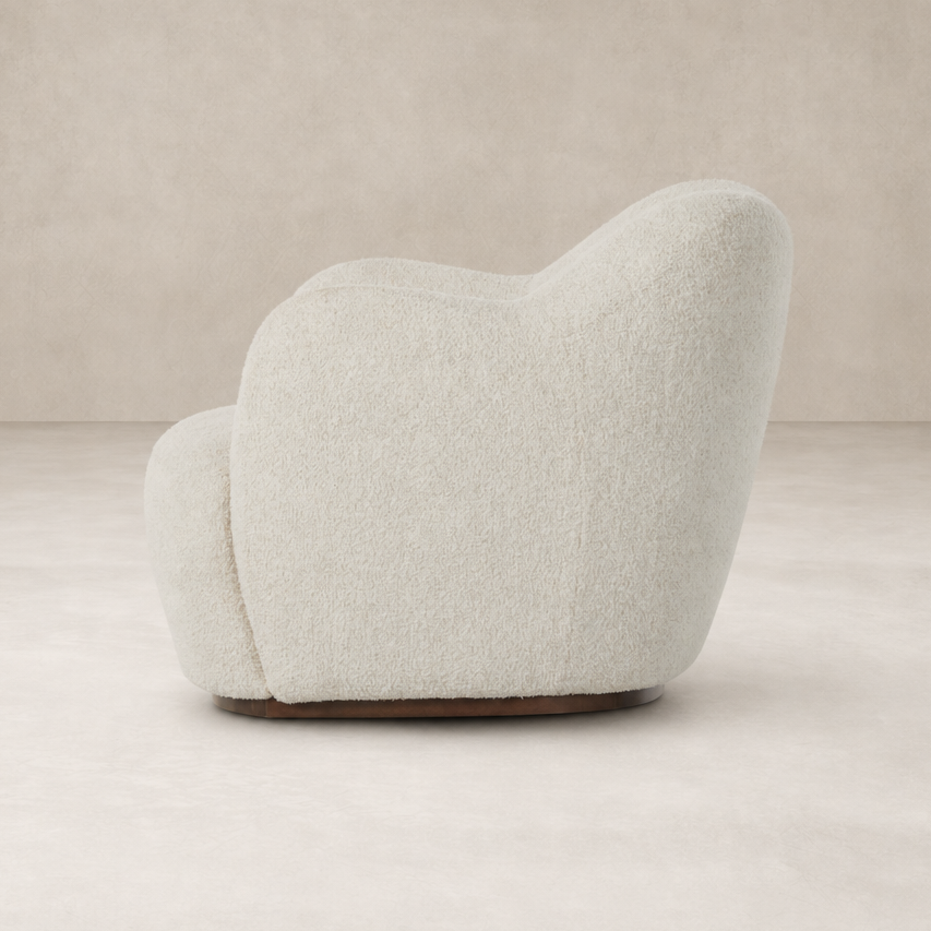 Poppy Swivel Chair in Sheldon Ivory with a rounded, plush silhouette and soft texture.