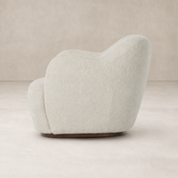 Poppy Swivel Chair in Sheldon Ivory with a rounded, plush silhouette and soft texture.