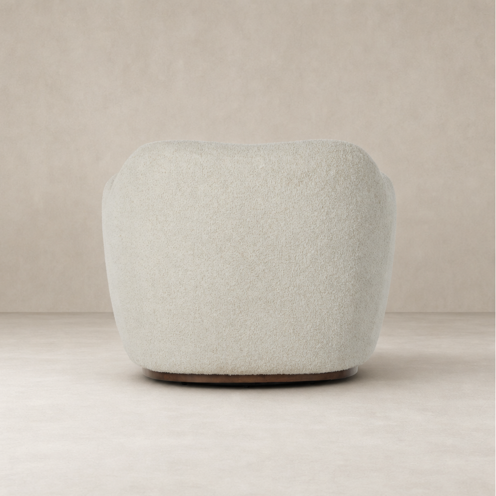 Poppy Swivel Chair in Sheldon Ivory featuring a plush rounded design and wooden base.