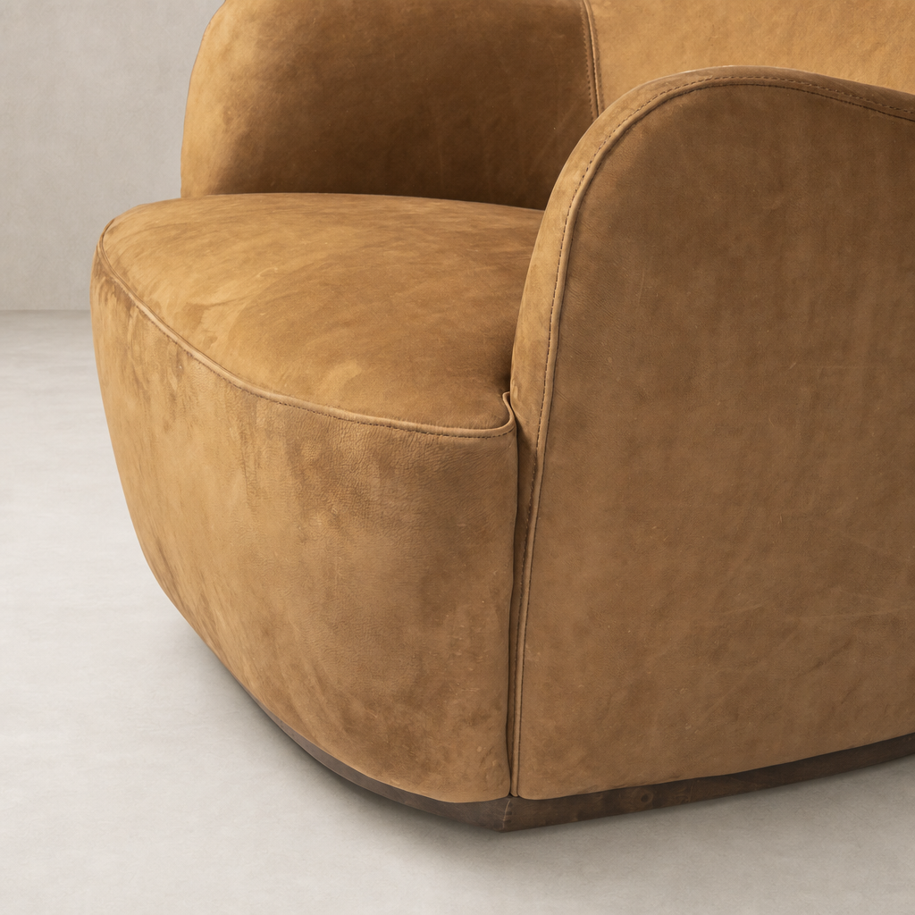 Poppy Swivel Chair in Nubuck Cognac with rounded edges and soft, luxurious texture.