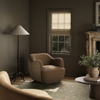Poppy Swivel Chair in Fallingbrook Cafe, featuring curved arms and textured fabric in a cozy setting.