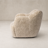 Beige shearling Poppy Swivel Chair with soft, rounded curves and plush texture.