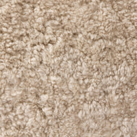 Close-up of the soft, textured beige shearling fabric of the Poppy Swivel Chair.