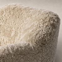 Close-up of the Poppy Swivel Chair in beige shearling, featuring a soft, textured fabric.