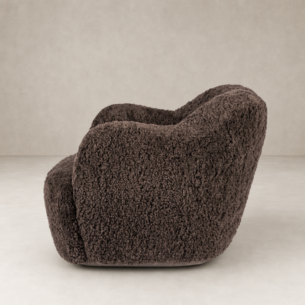 Cocoa shearling Poppy swivel chair with soft, rounded design and textured finish.