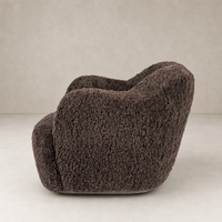 Cocoa shearling Poppy swivel chair with soft, rounded design and textured finish.