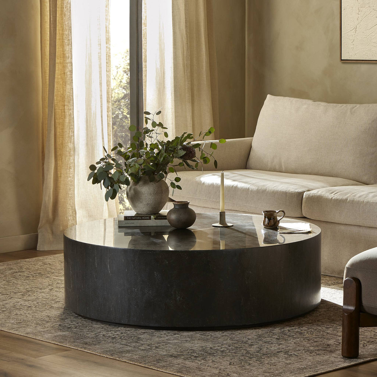 Milo Coffee Table in bluestone, featuring a sleek round design in a cozy living room setting.