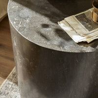 Keller End Table features a round, textured metal surface with a sleek finish.