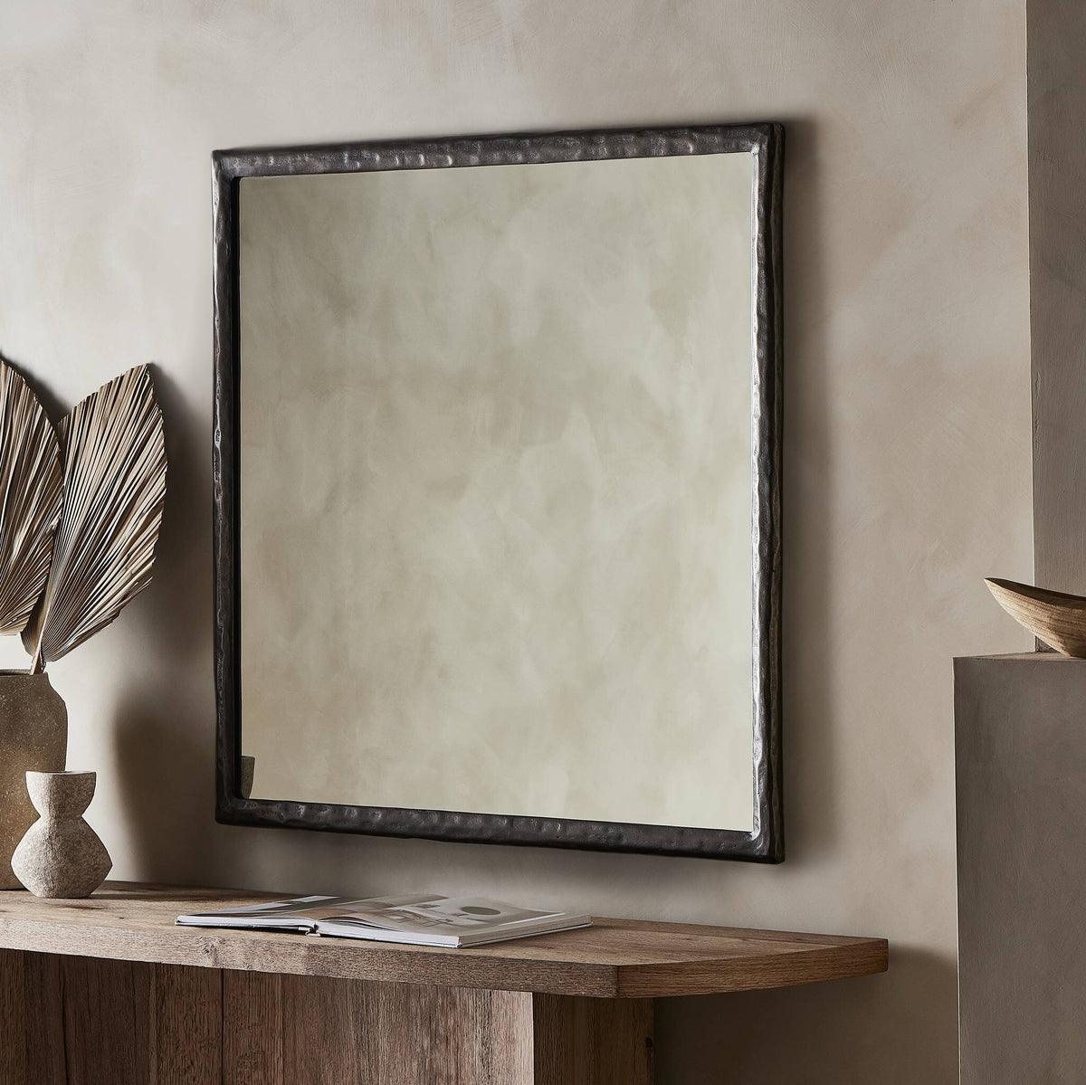 Bexley Wall Mirror in smoked nickel with a textured frame, displayed in a modern interior.