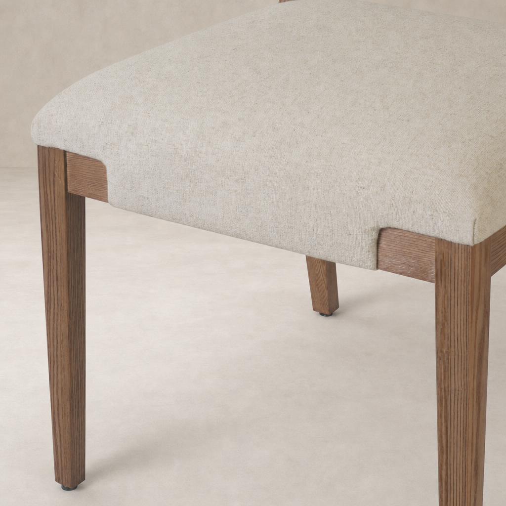 Nori Dining Chair in Antwerp Natural with soft fabric seat and sturdy wooden legs.
