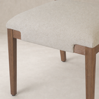 Nori Dining Chair in Antwerp Natural with soft fabric seat and sturdy wooden legs.