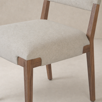 Nori Dining Chair in Antwerp Natural features a sleek design with soft cushions and wooden legs.