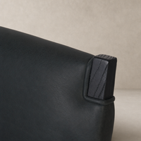 Close-up of the Nori Dining Chair showing the Brickhouse Black leather and wooden detail.