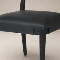 Nori Dining Chair in Brickhouse Black with sleek leather seating and sturdy wooden legs.