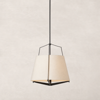 Matte black pendant light with a geometric shape and warm fabric shade.