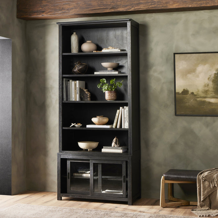 Zanzibar Bookcase in worn black showcasing open shelves and glass-fronted storage.