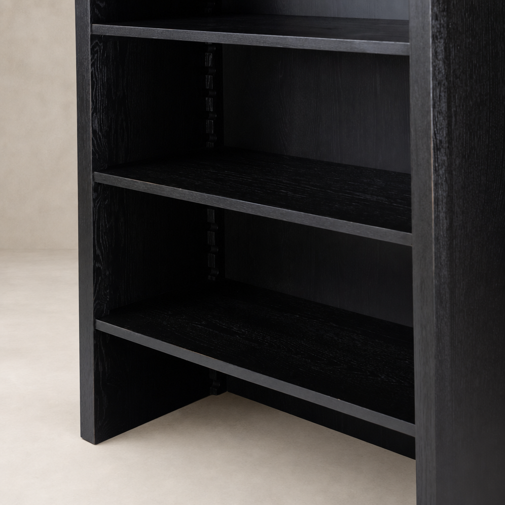 Worn Black Zanzibar Bookcase featuring open shelves and sleek design.