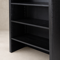 Worn Black Zanzibar Bookcase featuring open shelves and sleek design.